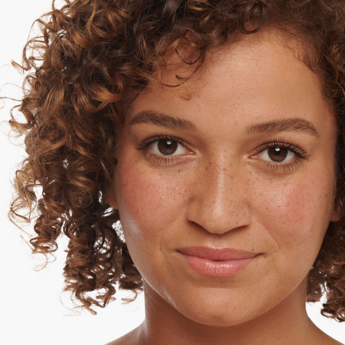 Woman with light-medium skin and curly auburn hair wearing Lash2Brow in Chestnut on her brows